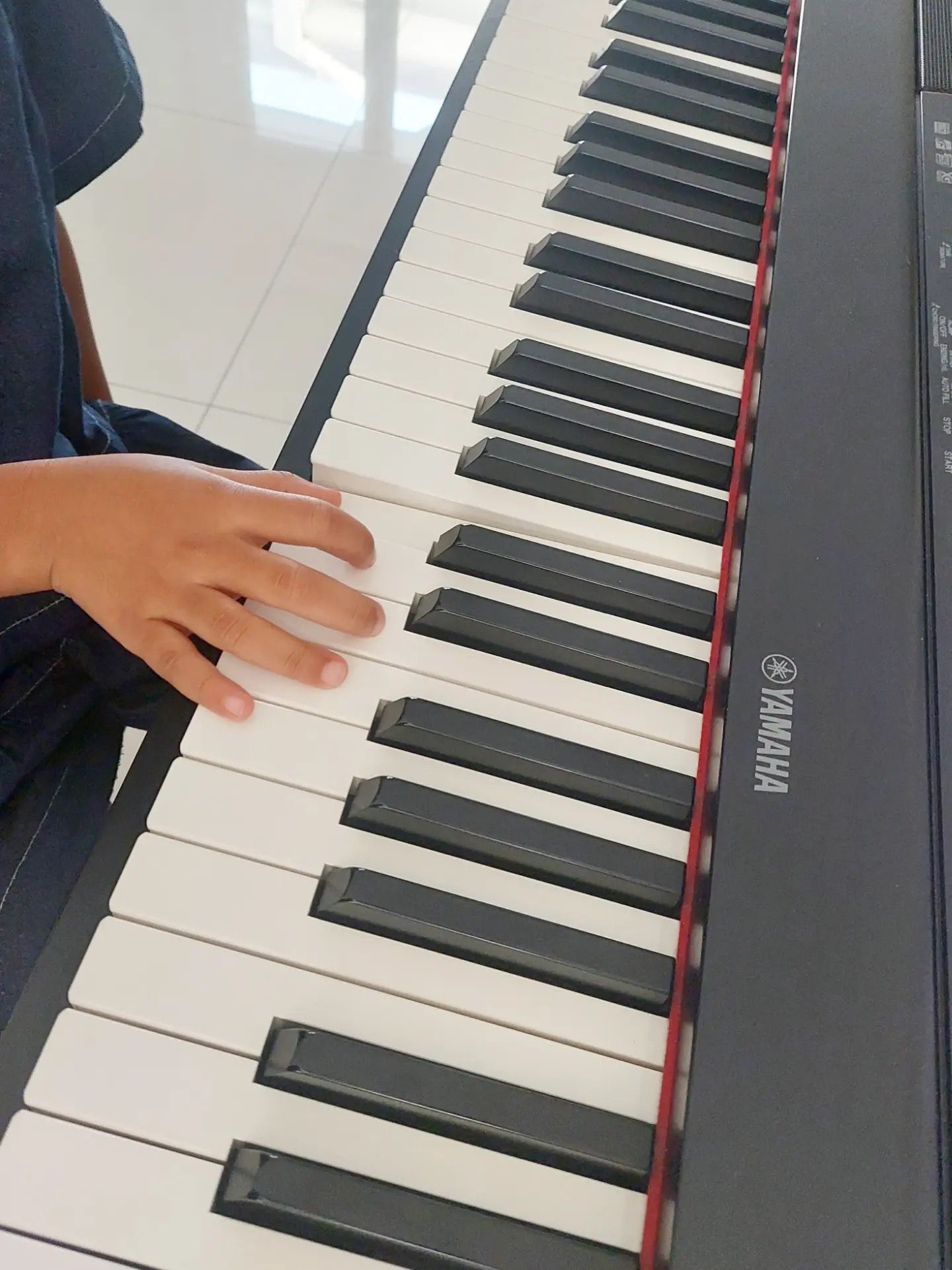 Tangan kecil di atas tuts piano